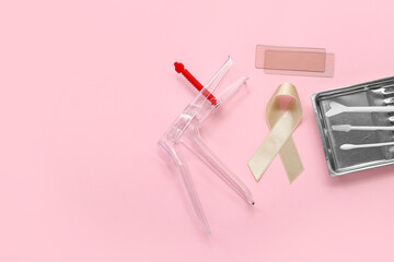 Beige ribbon with gynecological tools on pink background. Uterine cancer awareness concept