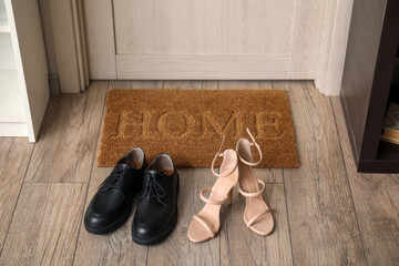 Doormat with word HOME and shoes in hall