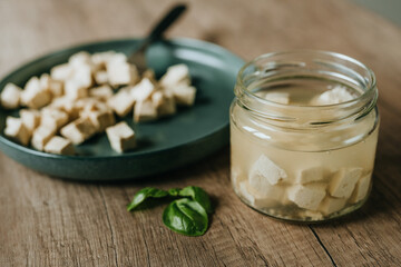 Tofu in a jar and in a plate on a wooden table