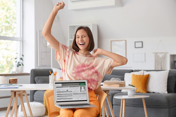 Happy teenage girl with approved college application on laptop at home