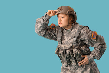 Vigilant young female soldier on blue background. Woman in male profession concept