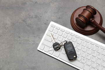 Car key with computer keyboard and auction gavel on dark background