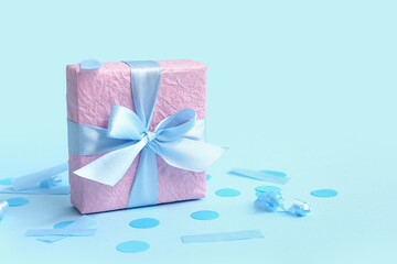 Pink gift box and confetti on blue background