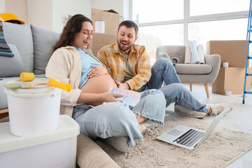 Young pregnant couple with paint color palettes planning repair in their new house
