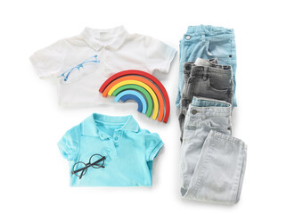 Set of stylish children's clothes, eyeglasses and toy rainbow on white background