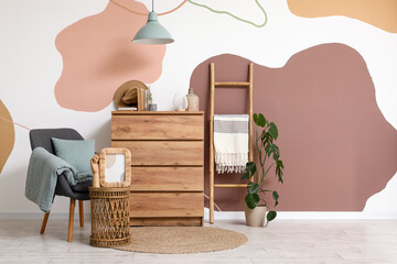 Interior of stylish living room with grey armchair, coffee table and dresser