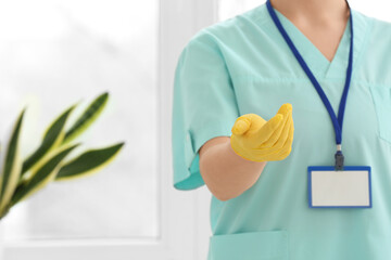 Female doctor in medical glove near window, closeup