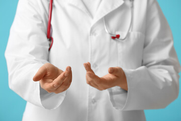 Female doctor showing something on blue background, closeup