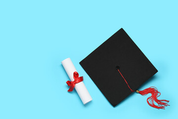 Mortar board and diploma on blue background