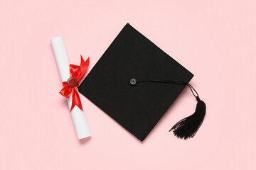 Mortar board and diploma on pink background