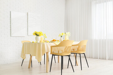 Elegant table setting with beautiful narcissus flowers in light dining room