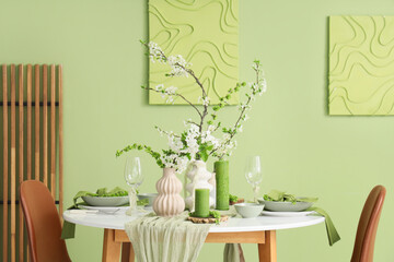 Elegant table setting with plates, candles and blooming tree branches