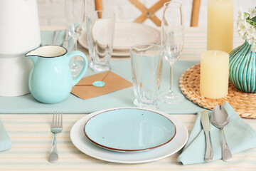 Elegant table setting with plates, glasses and blooming tree branches, closeup