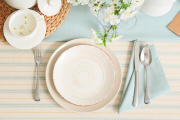 Elegant table setting with plates, cutlery and blooming tree branches