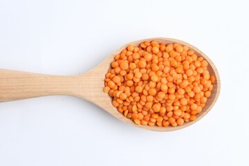 Raw lentils in wooden spoon isolated on white, top view