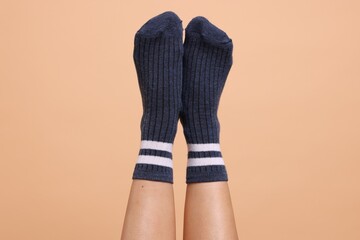 Woman in stylish socks on beige background, closeup