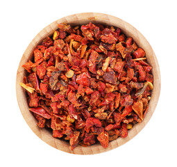 Red chili pepper flakes in bowl isolated on white, top view