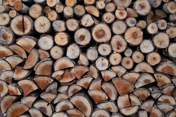 A close-up view of neatly stacked logs, showcasing their natural wood grain and circular cut...