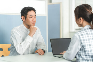 Obraz premium 窓口で落ち込みショックを受ける男性顧客と接客する女性スタッフ 