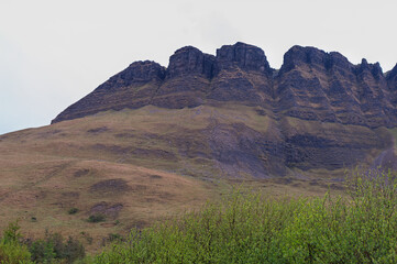 A mountain with a rocky, grassy slope