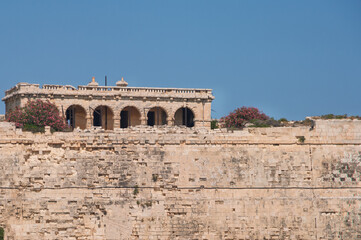 Fototapeta premium A building with a balcony and a wall of stone