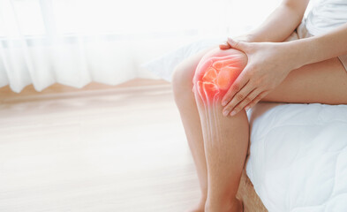 Woman hands touching her knee area. Bone pain, Trauma or Torn ligament in the knee area. Healthcare and medical concept