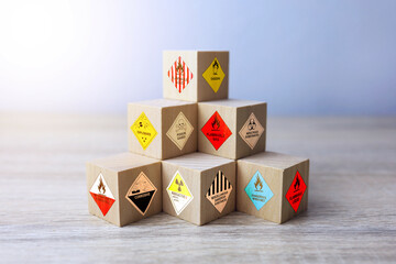 The symbols of dangerous goods or flammable chemicals on wooden cubes convey a warning and must be...