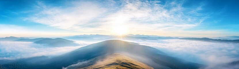 Panoramic view of Carpathian Mountains with foggy valley and sunlight on mountain peak under vibrant blue sky with clouds, wide high-resolution morning landscape background
