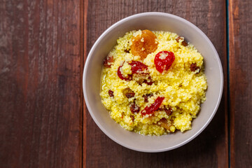 Couscous with dogwood nuts and raisins in a plate on the table.
