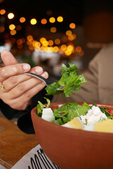 Fresh salad being enjoyed in a cozy, illuminated restaurant setting