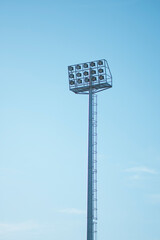 Tall metal pole with multiple stadium lights against a clear blue sky © 5 Grace Media