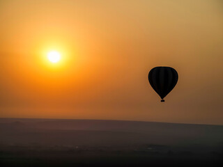 Hot Air Balloon Silhouette Against a Fiery African Sunset. Maasai Mara, Kenia, Africa.