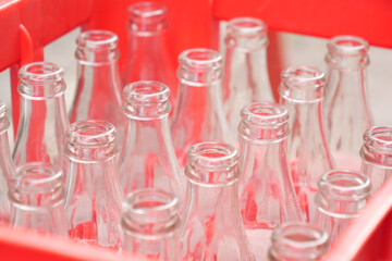 Glass bottles neatly arranged in a red crate at a market