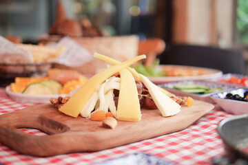 Cheese platter displays variety of cheeses and snacks in cozy setting