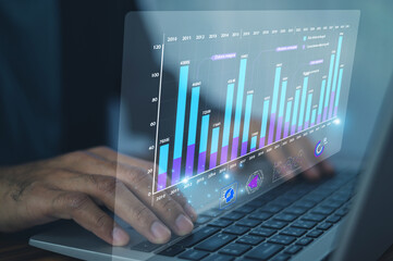 Business professional analyzing interactive digital bar charts to monitor performance metrics and...