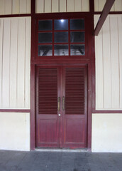 An ancient but well maintained wooden door in an old house building. Suitable for use as a background with a horror theme
