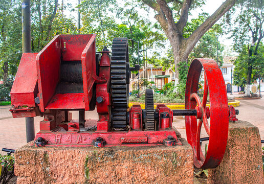 Vintage Red Industrial Machine in Villeta Park, Cundinamarca, Colombia, Surrounded by Lush Greenery