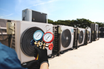 Electrical conditioning service technician using measuring manifold gauge checking HVAC condition...