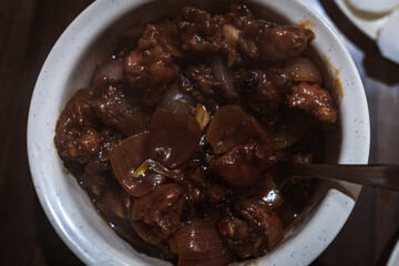 Close-up of spicy Indian-style Chicken Chilly served in a ceramic bowl — a popular Indo-Chinese dish made with crispy fried chicken, onions, and tangy sauces.