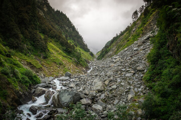 Glacial river flowing under snow bridge in the Himalayas, Himachal Pradesh
