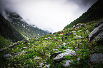 Group of trekkers with hiking backpacks on beautiful mountain landscape background. Climbers hike...