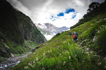 Obraz premium Group of trekkers with hiking backpacks on beautiful mountain landscape background. Climbers hike to mountains. Group of hikers walking in mountains 
