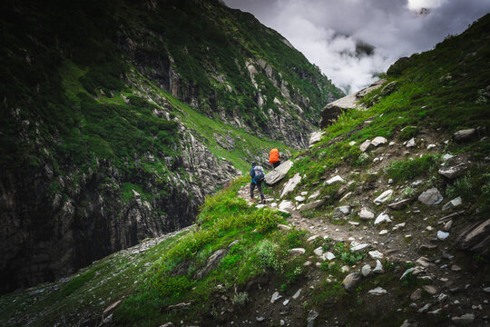 Group of trekkers with hiking backpacks on beautiful mountain landscape background. Climbers hike to mountains. Group of hikers walking in mountains	
