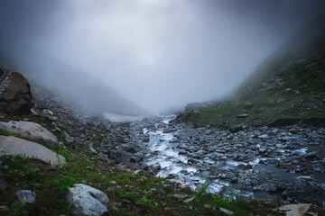 Glacial river flowing under snow bridge in the Himalayas, Himachal Pradesh


