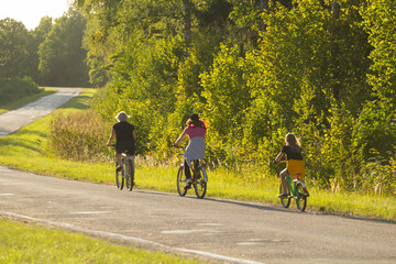 Obraz premium Family Cycling Together On A Scenic Path In A Lush Green Forest