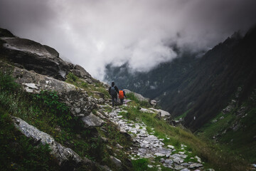 Group of trekkers with hiking backpacks on beautiful mountain landscape background. Climbers hike to mountains. Group of hikers walking in mountains 