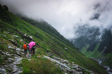 Fototapeta premium Group of trekkers with hiking backpacks on beautiful mountain landscape background. Climbers hike to mountains. Group of hikers walking in mountains 