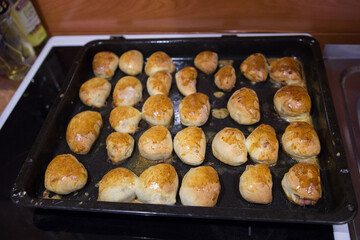 Freshly Baked Golden Brown Pastries on a Black Cooking Tray