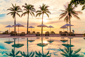 Umbrella and chair around swimming pool in resort hotel for leisure travel and vacation neary sea...