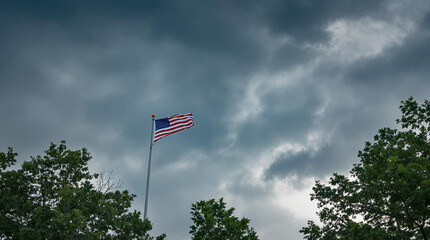 american flag waving in the wind of the storm sky